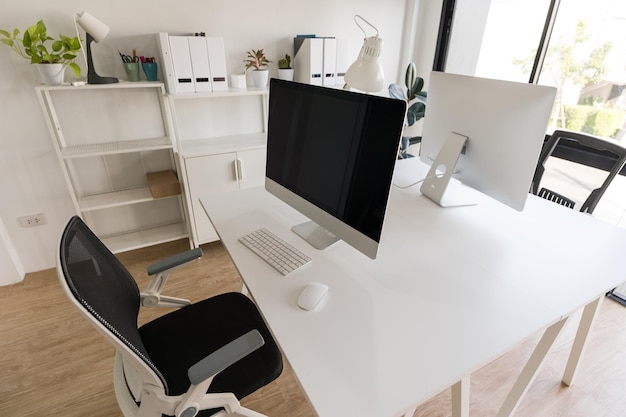 White table and chair with computer monitor and modern file cabinet in white home office