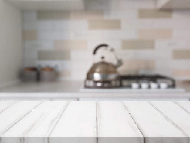 White table surface in front of blur kitchen counter