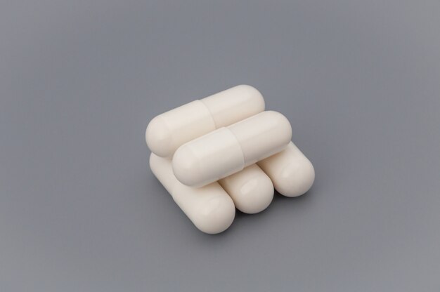 White tablets are stacked on a gray background.