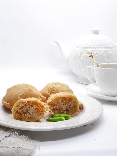 A white tea pot with a tea pot and a plate of food on it.