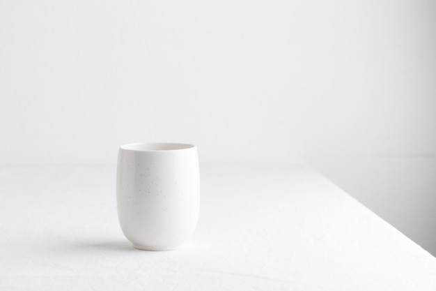 White teacup on a table on a white background