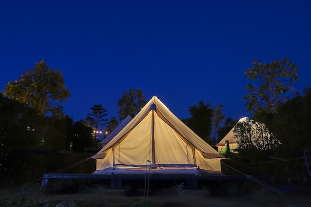 The white tent is camping in the garden at night