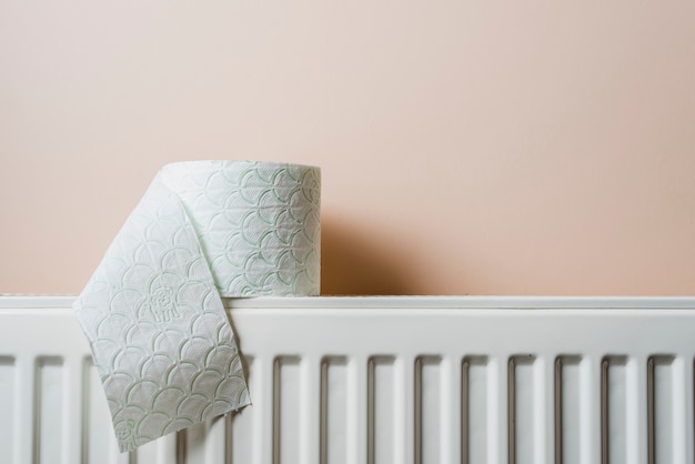 White toilet paper on radiator against wall