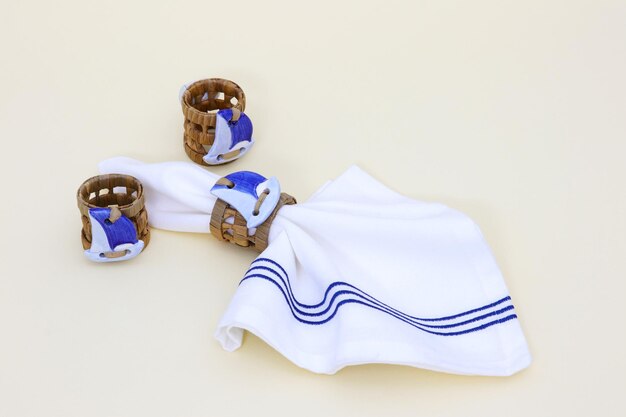 A white towel with blue stripes is laying next to a basket and a towel.