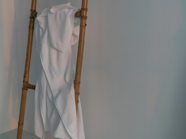 White towel on wooden ladder in white room