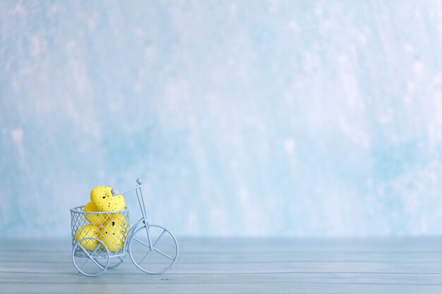 White toy bicycle with yellow Easter eggs