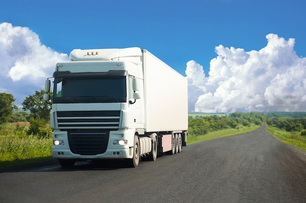 White truck moving on a road in summer