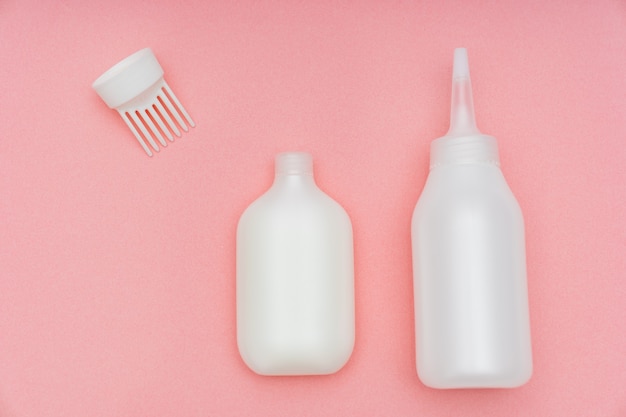 A white tube with paint and a bottle with a convenient applicator