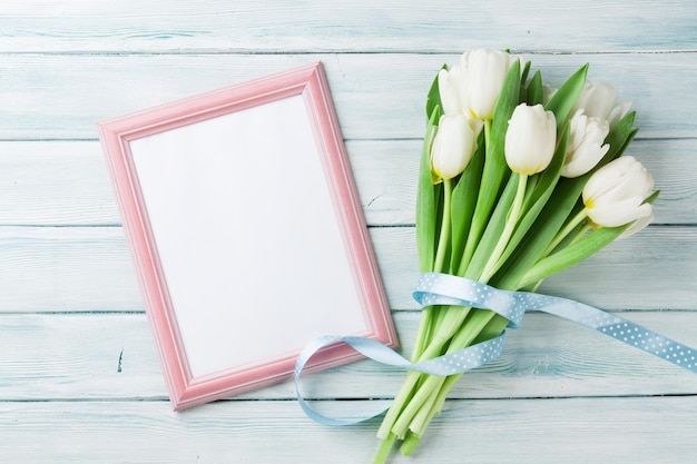 White tulips bouquet and blank photo frame