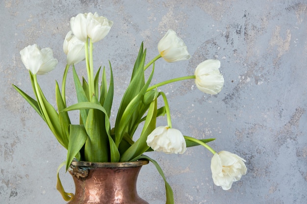 White tulips in old copper vase