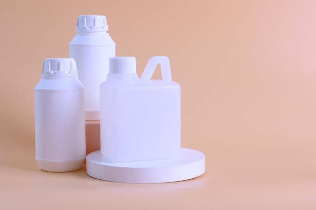 White unbranded plastic medicine bottles mockup for vitamins or pills with jerrycan on podium agains