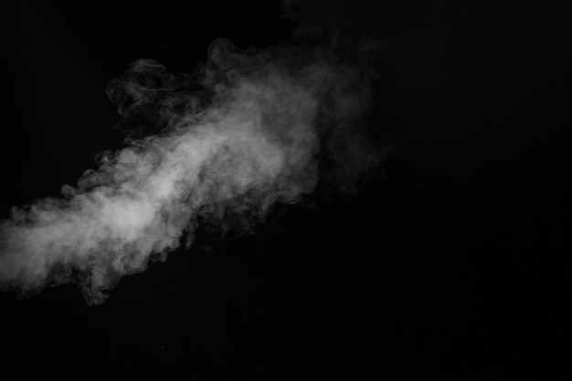 White vapor spray steam from air saturator. Smoke fragments on a black background. Abstract background, design element, for overlay on pictures