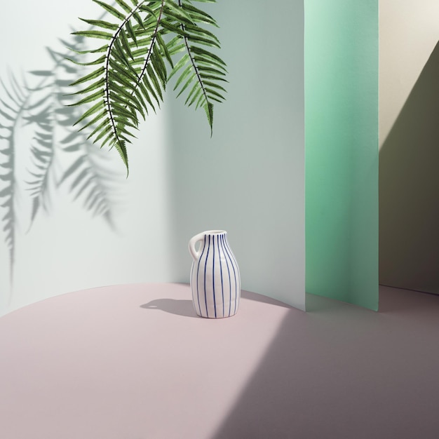 White vase with blue stripes in pastel turquoise background. Stylish Scandinavian interior wall. Home decor. Natural background concept. Minimalistic design.