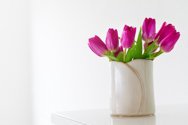 White vase with purple tulips