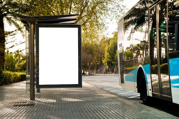 White vertical billboard, with bus on the city street