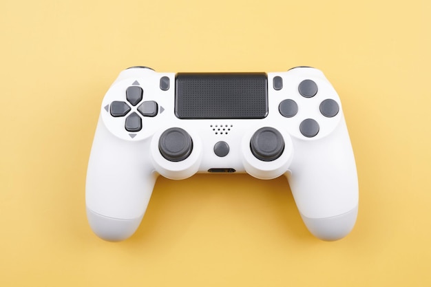 White video game controller joystick for game console isolated on yellow background Gamer control device closeup