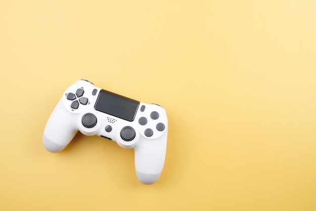 White video game controller joystick for game console isolated on yellow background Gamer control device closeup