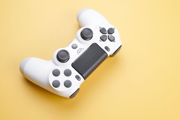 White video game controller joystick for game console isolated on yellow background Gamer control device closeup