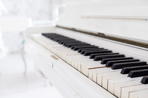 White vintage piano in a white room