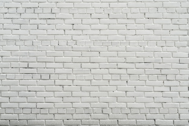 White wall of the house. Old brick wall. White paint on a brick wall.