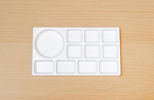 White watercolor palette Empty watercolor tray isolated on wood background