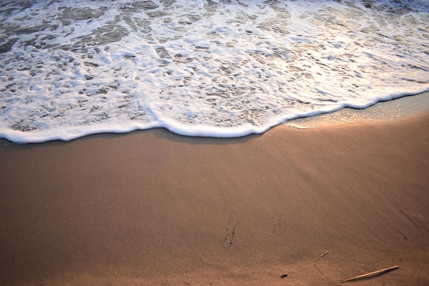 White wave of blue sea on sandy beach Natural background