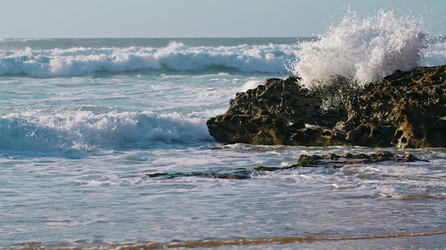 White waves crashing rocks in sunny morning Storming ocean landscape view