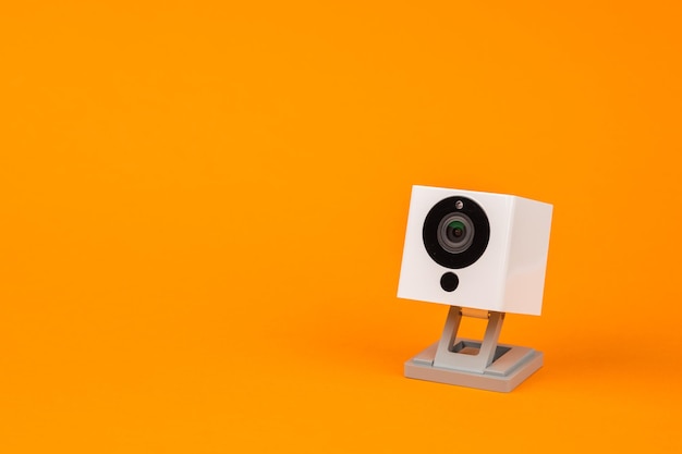 White webcam on orange background, object, Internet, technology concept.