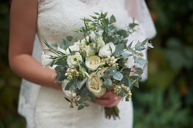 White wedding bouquet in the hands of the bride.