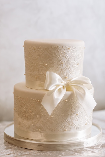 White wedding cake with ribbon and pearls