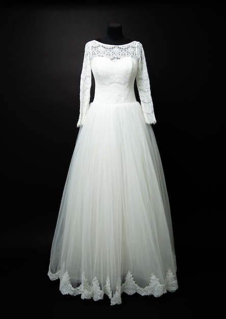 White wedding dress on black background in studio