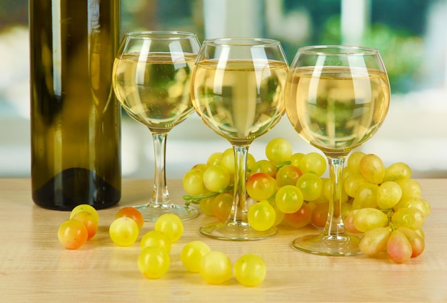 White wine in glass with bottle on window background