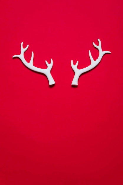 Photo white winter festive christmas reindeer antlers on a red background