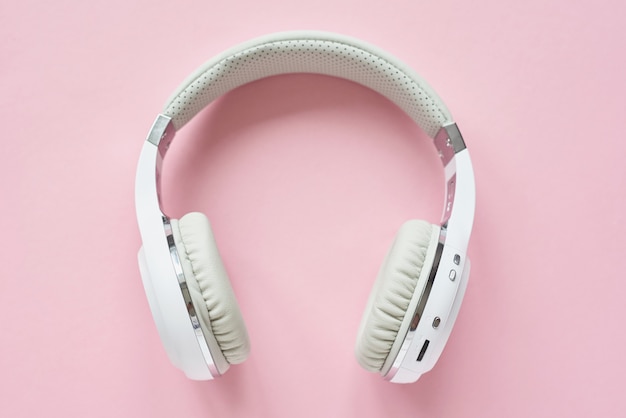 White wireless headphones on a pastel blue background