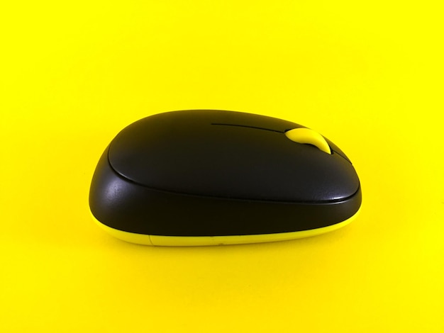 White wireless mouse on yellow background minimal flatlay