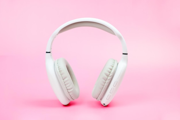 White wireless onear headphones on pink background