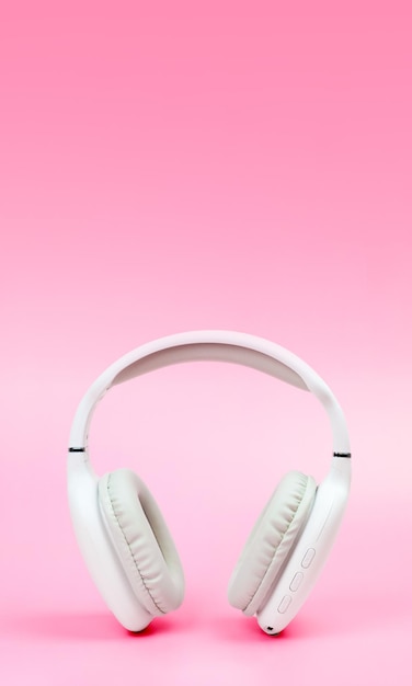 White wireless onear headphones on pink background