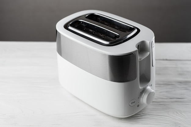 White with silver toaster on gray wall on wooden white table