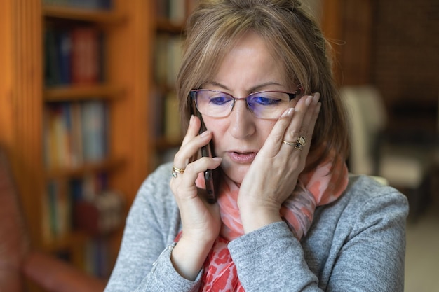 White woman very worried about the bad news that she is given by mobile phone