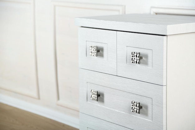 White wooden chest of drawer in the interior of an room