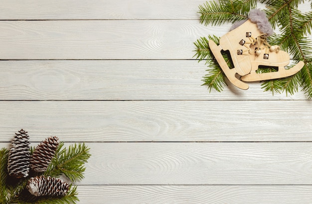 White wooden christmas background with fir branches, cones, decor, top view, copyspace.