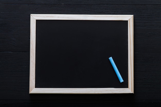 White wooden frame with chalk inside on blackboard