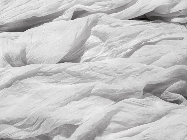 White wrinkled crumpled light fabric on the bed the texture of the fabric Layout for the poster