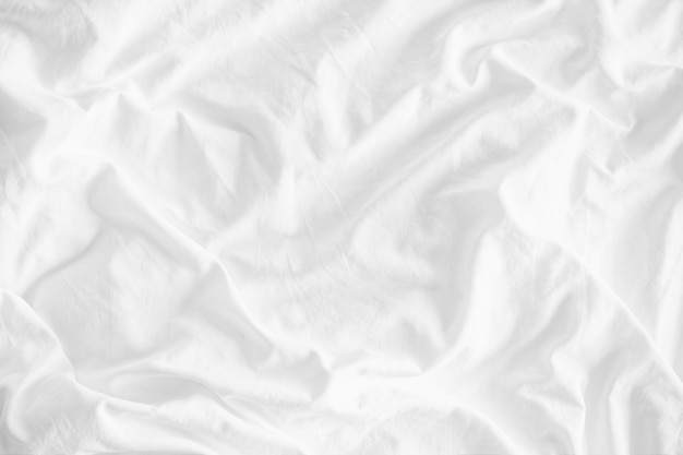 White wrinkled fabric texture rippled surface, Close up unmade bed sheet in the bedroom 