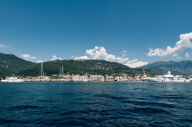 White yacht sails to the coast of the expensive resort of porto montenegro