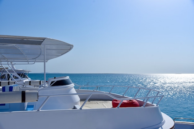 White yacht at sea against blue sky.