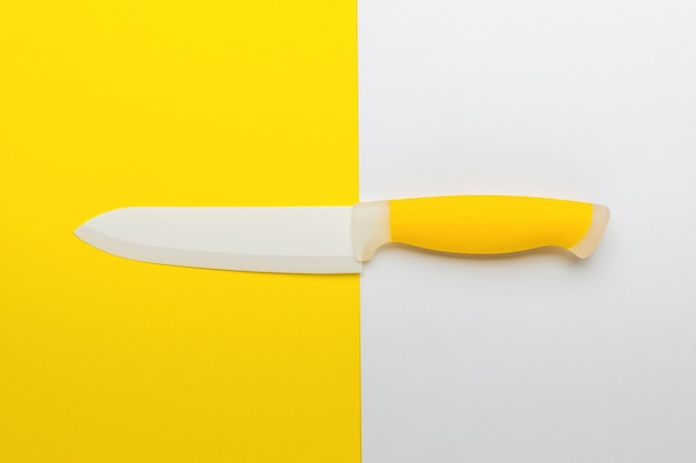 White and yellow kitchen knife on a white and yellow kitchen background Accessory for cooking Flat lay