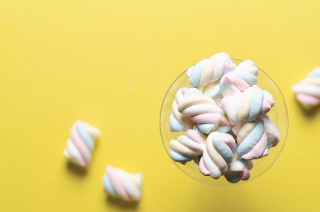 White, yellow, pink, and light blue marshmallows on yellow background.