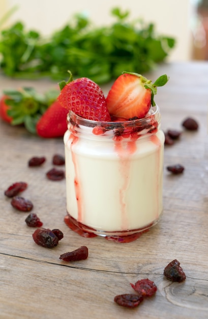 White yogurt with red fruits in the glass jar