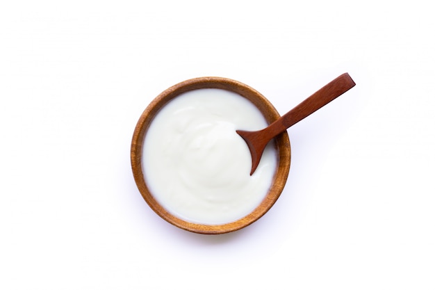 White yogurt in wooden bowl on white background.